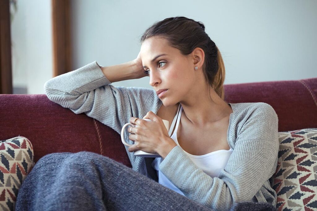woman on couch considers the signs of depression