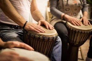 man hits a bongo in a music therapy program in massachusetts 