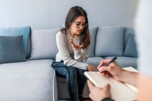 woman sitting on couch talks with therapist about fentanyl addiction treatment 